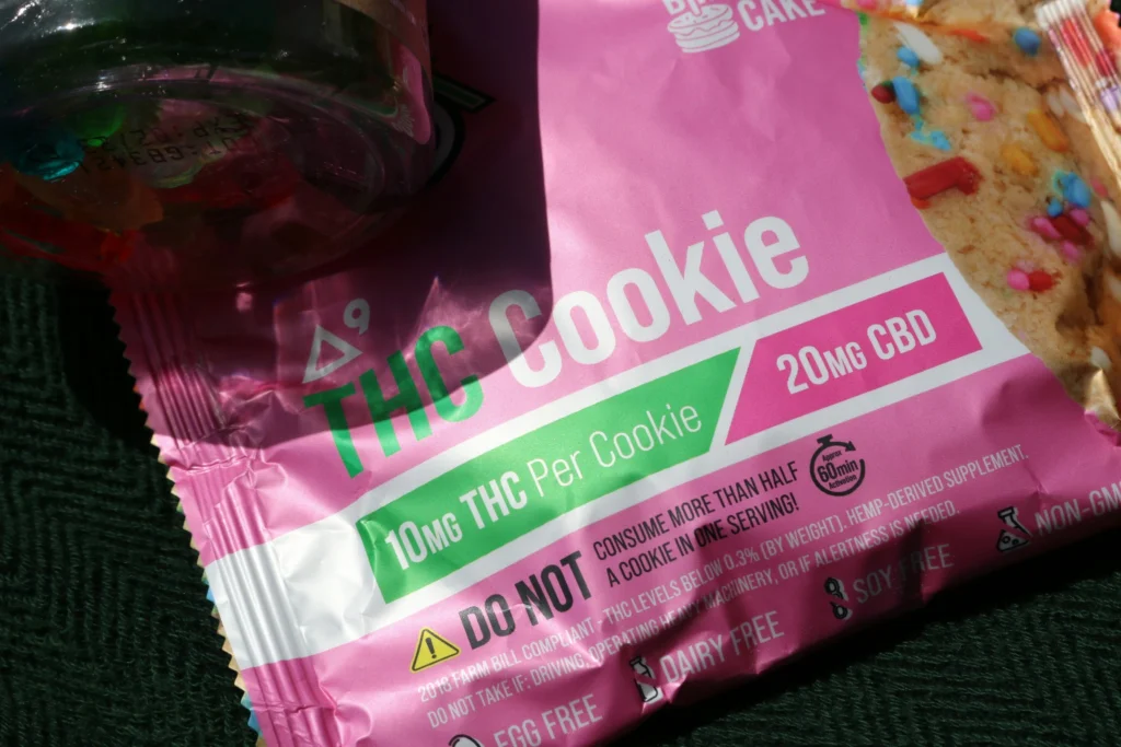 Pink packaging of THC cookies labeled with 10mg THC and 20mg CBD per cookie, highlighting dietary info.